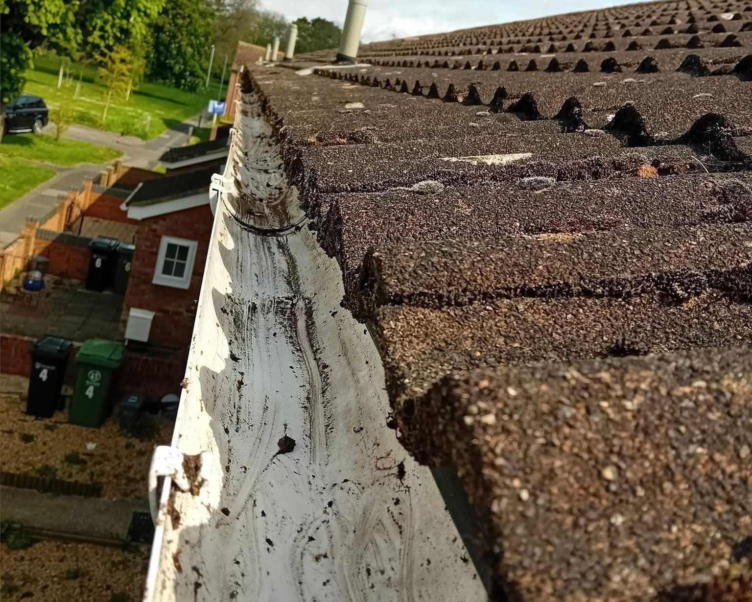 Gutter interior after wet-vac emptying — debris removed back to the gutter base